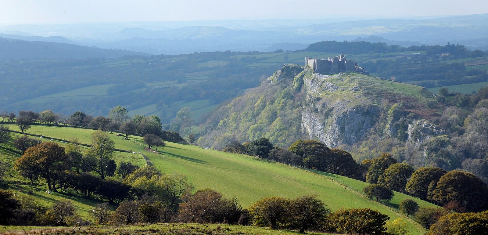 Carreg Cennen Castle on a limestone crag above green fields